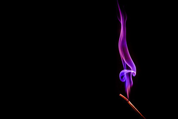 An incense stick burns and smokes.