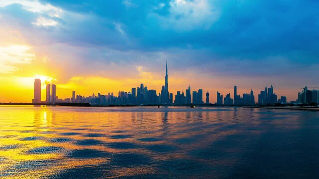 Dubai city skyline day to night transition timelapse with towers and modern buildings panoramic view. 4k Time lapse video shot on a cloudy day with moving clouds Dubai, United Arab Emirates