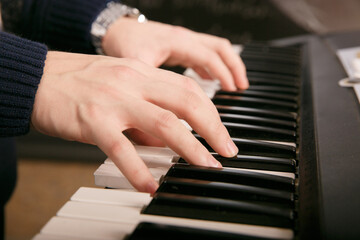 Hands of male musician playing at synthesizer. Mens arms plays solo of music or new melody. Close...