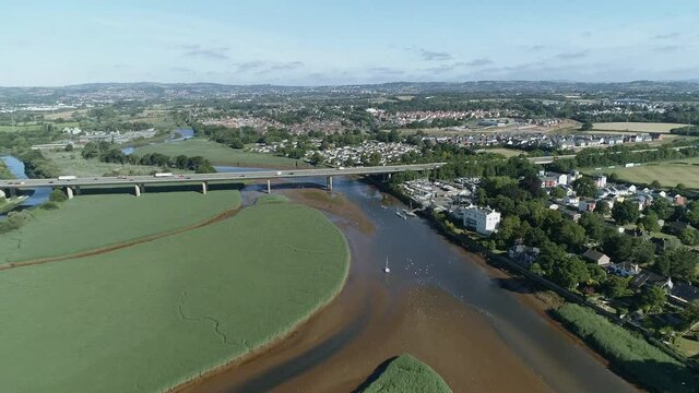 Topsham, Devon aerial tracking forward towards the M5 flyover. Sand flats and coastal birds