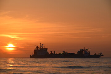 Fototapeta premium Bright sunset over ships at sea