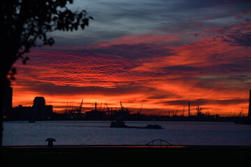 Fototapeta premium Deep red sky over silhouetted cityscape