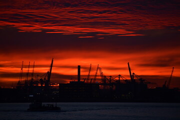 Obraz premium Deep red sky over silhouetted cityscape