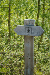 Wooden hiking post showing the hiking direction in the nature of Norway.