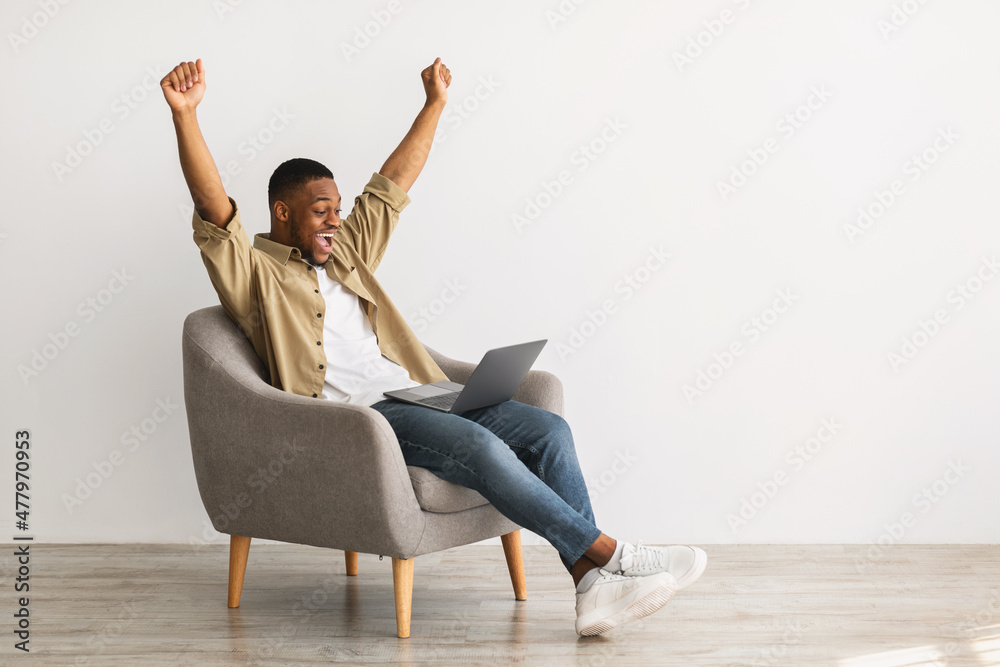 Sticker African Freelancer Man With Laptop Shaking Fists Over Gray Wall