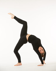 Naklejka premium A girl in black clothes on a white isolated background performs dance and ballet poses and movements.
