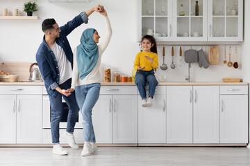 Cheerful Arab Parents And Little Daughter Having Fun In Kitchen At Home