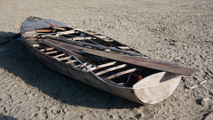 hull of a shipwrecked small sailboat on the beach - 477972579