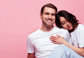 young cheerful caucasian couple together having fun on pink background, guy ang girl modern relationship, lifestyle people concept