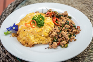 Spicy fried pork with basil leaves, the famous traditional Thai food served with jasmine rice and fried egg.