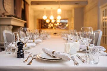 photo of a table in a restaurant with plates, wine glasses, knife and fork..