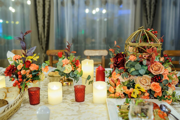 Autumn flower table decorations in a pumpkin, with candles. .