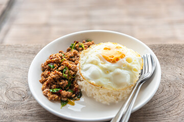 Spicy fried pork with basil leaves, the famous traditional Thai food served with jasmine rice and fried egg.