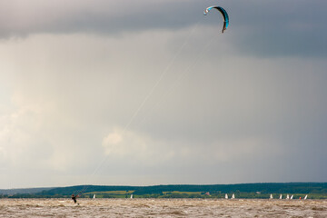 Kitesurfing on the water on the waves with a parachute wing. Wind, speed.