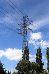 High voltage powerline pylon against blue sky.

