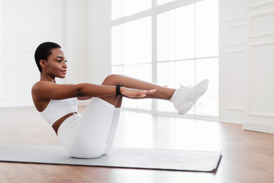 Focused Young Black Woman Doing Crunches Exercise On Yoga Mat - Powered by Adobe