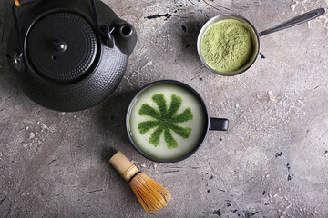 Cup of tasty matcha coffee with powder on grunge background with space for text