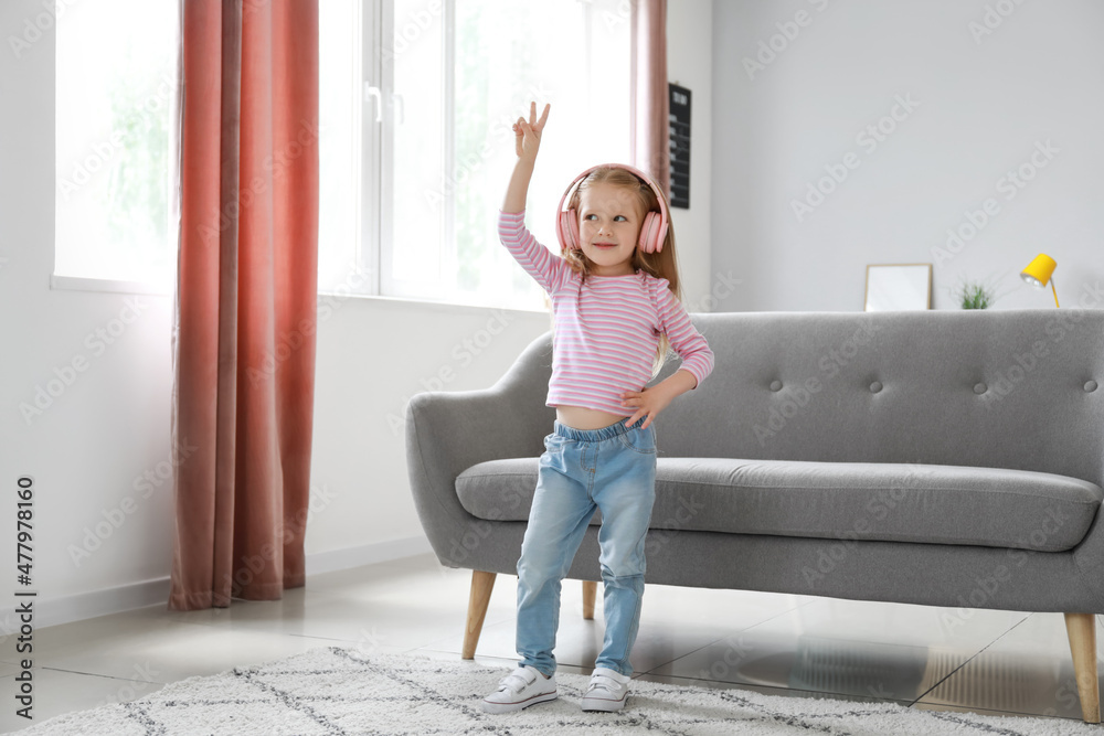 Sticker Cute little girl in pink headphones dancing at home