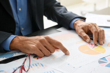 Businessman working with documents at desk in office, closeup