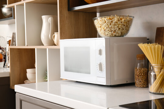 Modern Microwave Oven With Bowl Of Popcorn On Counter In Kitchen