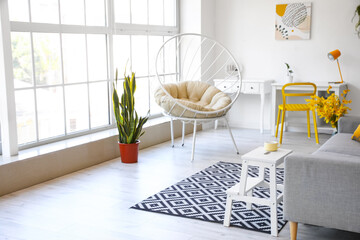 White step stool with cup near sofa in living room