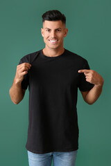 Fototapeta premium Handsome young man in stylish t-shirt on color background