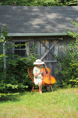 Female playing her cello outside. © oscar williams