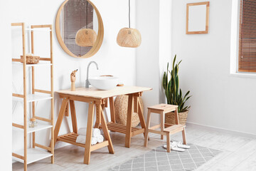 Interior of light bathroom with sink, mirror and step stool