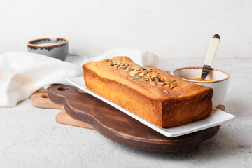 Plate with tasty pumpkin pie on light background