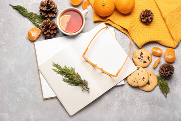 Composition with notebooks, eyeglasses, cup of tea and cookies on grunge background. Hello winter