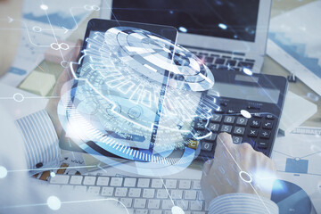 Double exposure of man's hand holding and using a digital device and data theme hologram drawing. Technology concept.