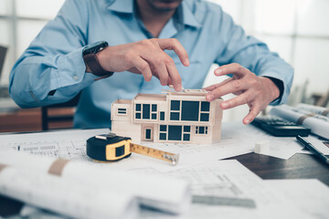 Architect engineer design house model on bueprint. House planning design and construction concept.