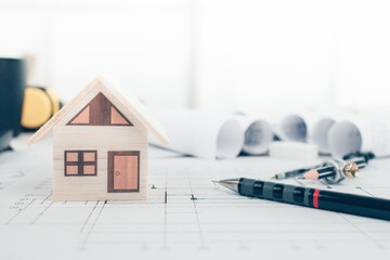 Mini model house, pencil, compass  and roll blueprint plan  on blueprint house plan design....