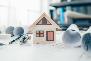 Mini model house, pencil, compass  and roll blueprint plan  on blueprint house plan design....