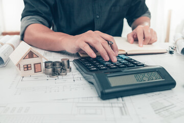 Architect engineer use calculator check cost house design on bueprint. Cost House planning design...
