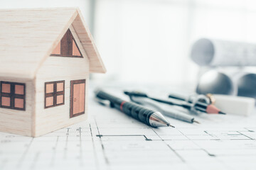Mini model house, pencil, compass  and roll blueprint plan  on blueprint house plan design....