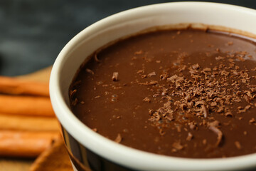 Cup of natural hot chocolate on black background, closeup