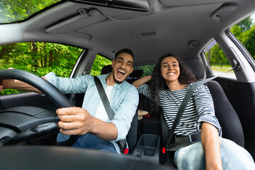 Emotional millennial couple enjoying journey by auto