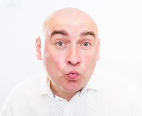 portrait of a bald adult man with emotions on a white background