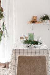 Beautiful table setting with pine cones and fir branches indoors