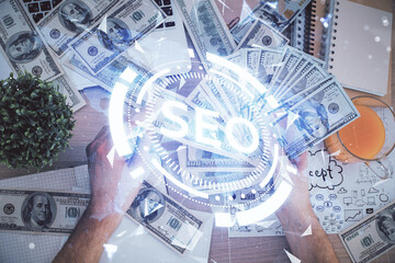 Multi exposure of seo drawing hologram and us dollars bills and man hands.