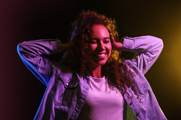 Toned portrait of beautiful young woman on black background