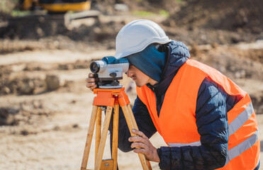 Surveyor worker with theodolite equipment at construction site
