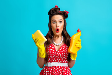 Shocked pinup woman in polka dot dress holding toilet detergent and sponge, making surprised face...