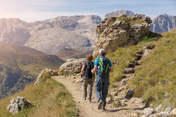 Obraz premium Senior tourist couple hiking in the beautiful mountains. Passo Sella - Sassolungo, South Tyrol, Italy 
