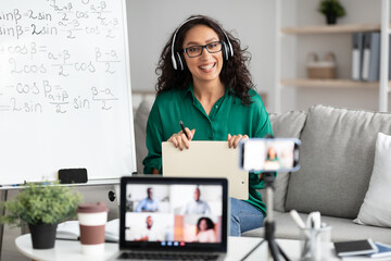 Female teacher giving online lecture to students recording video