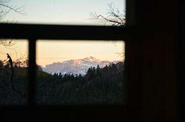 sunset in the mountains. The S&auml;ntis mountain in the Appenzell Alps lights up in the last light. snow on the peak.
