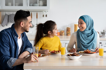 Domestic Breakfast. Happy Middle Eastern Family Of Three Eating Together In Kitchen
