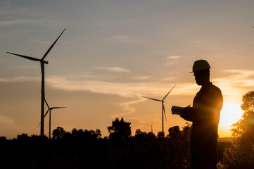 Asian Man engineers working and holding the report at wind turbine farm Power Generator Station on...