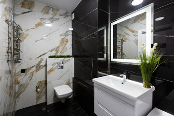 Interior of a modern small bathroom with white and black marble tiles